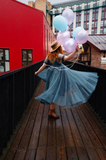 istock Girl walks streets with bunch balloons 1402475235