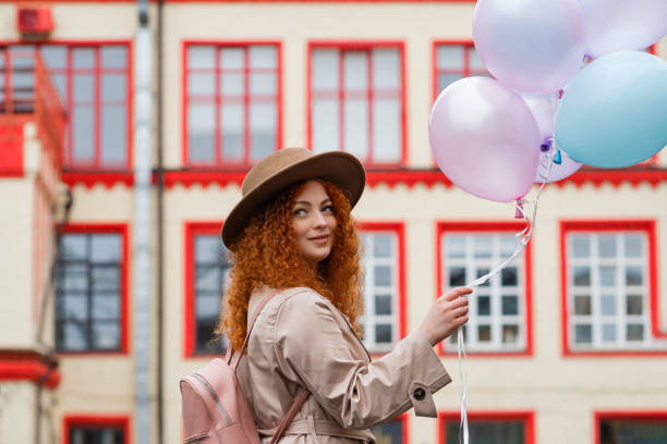 istock Girl walks streets with bunch balloons 1402475236