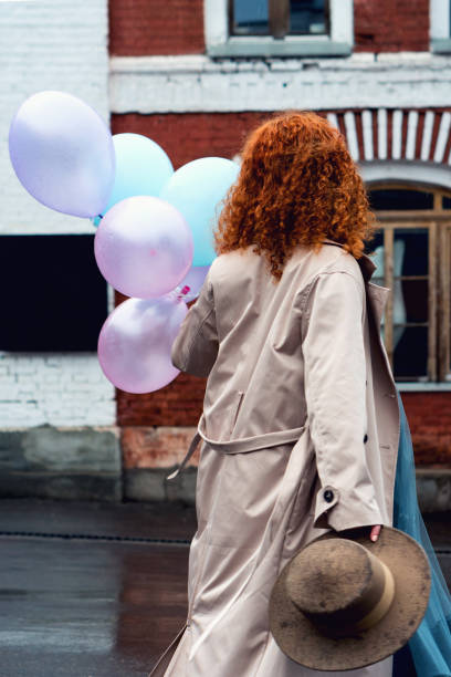 istock Girl walks streets with bunch balloons 1402475238