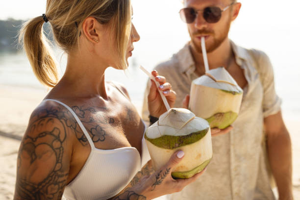 istock Caucasian couple drinking coconut on the beach 1402475674