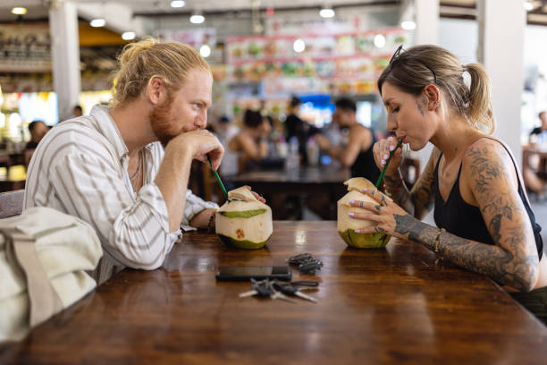 istock Caucasian couple drinking coconut at the modest Thai restaurant 1402475911