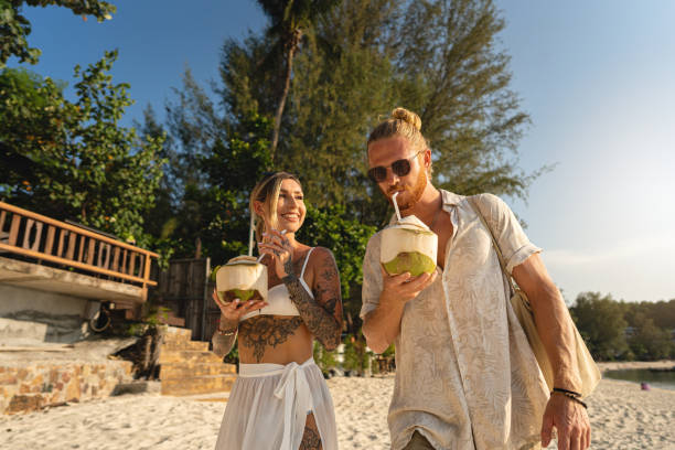 istock Caucasian couple drinking coconut on the beach 1402476591