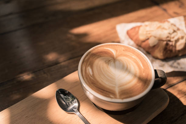 tazza di caffè caldo e croissant appena sfornato su sfondo di legno. - heart shape snack dessert symbol foto e immagini stock