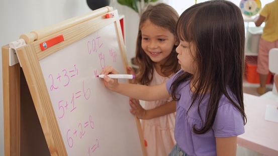 Preschool teacher with children study in classroom. Kindergarten back to school