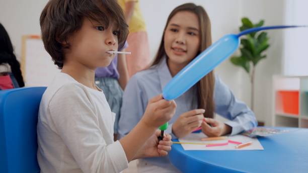 istock Preschool teacher with children study in classroom. Kindergarten back to school 1402476825