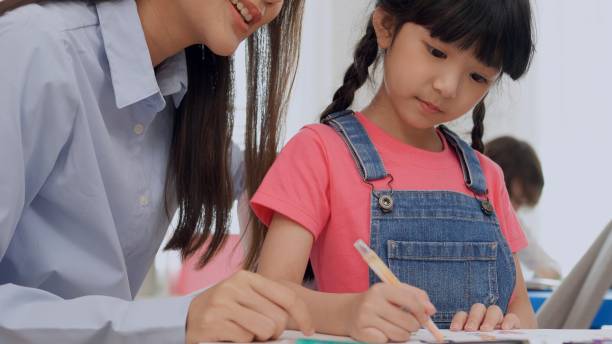 istock Preschool teacher with children study in classroom. Kindergarten back to school 1402477065