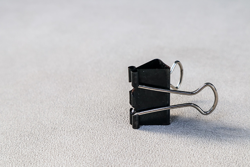 binder clip on the table with a white rough texture