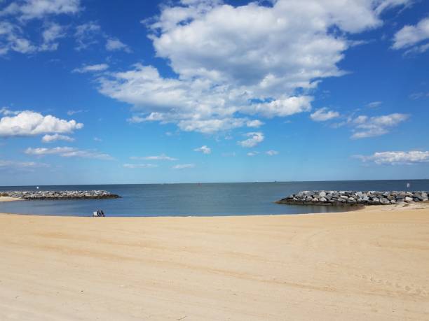 istock sand and rocks and water and clouds at beach 1402478383