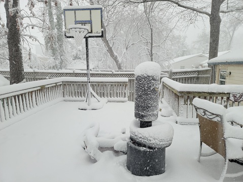 punching bag and basketball hoop on deck covered in snow in winter