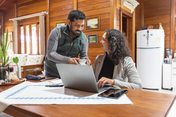 istock Latin woman working laptop with husband serving tea 1402480449