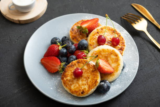 istock Roasted cheesecakes on a plate with powdered sugar and berries angle view 1402485449