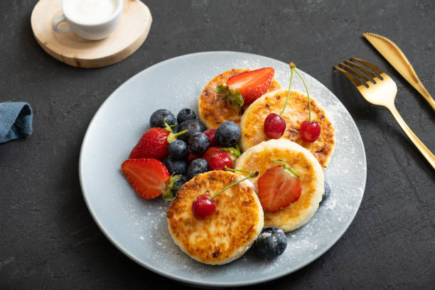 istock Roasted cheesecakes on a plate with powdered sugar and berries angle view 1402485540