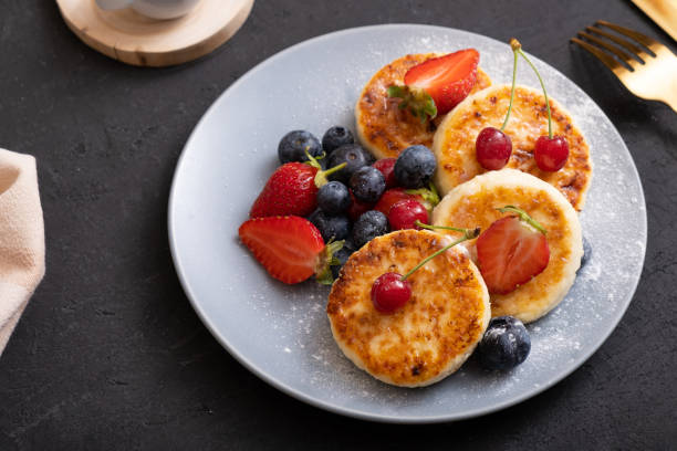 istock Roasted cheesecakes on a plate with powdered sugar and berries angle view 1402485621