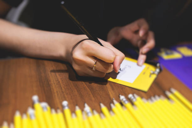 istock Process of checking in on a conference congress forum event, registration desk table, visitors and attendees receiving a name badge and entrance wristband bracelet and register electronic ticket 1402486914