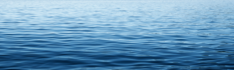 The calm waves on the surface of a large body of water such as a lake or the ocean.