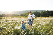 Mother having fun with child girl in flower meadow