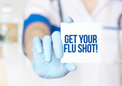 Obtenga el texto de su vacuna contra la gripe en la tarjeta en manos del médico de cerca photo