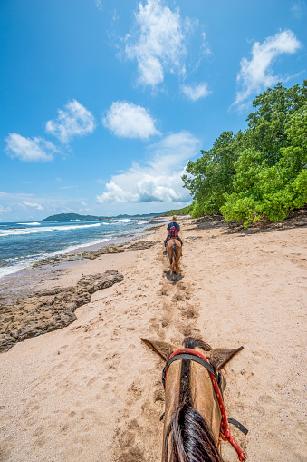 Tamarindo Beach, Costa Rica - May 29, 2022: Young woman horseback riding at Tamarindo Beach.