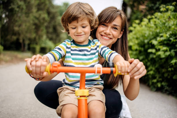 Yes, you can Mother learning her son to drive i bike playing children stock pictures, royalty-free photos & images