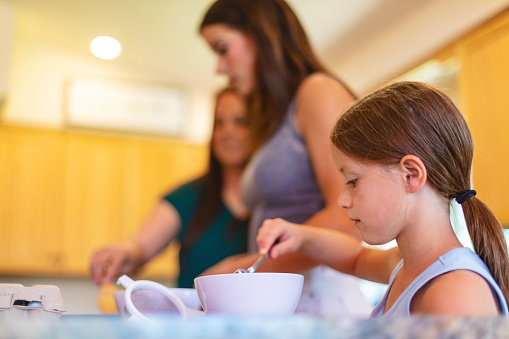 Active Family in Western USA Sharing Quality Time Together Mother and Female Children in Home Cooking French Toast in Domestic Kitchen and Eating Breakfast Together Family Photo Series