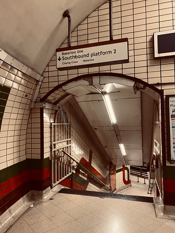 London, UK - Newly arrived passengers walking along the platform of Euston's London Underground station as the train departs.