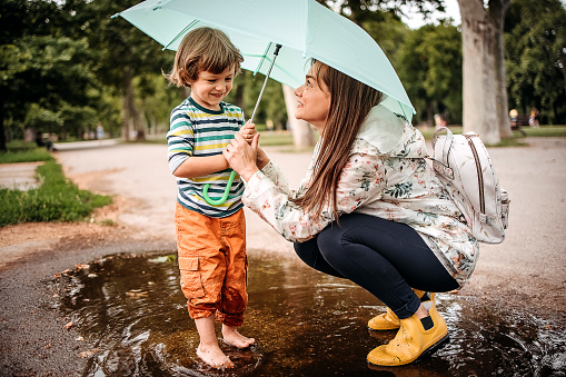 Happy family playing in the street after a rain.