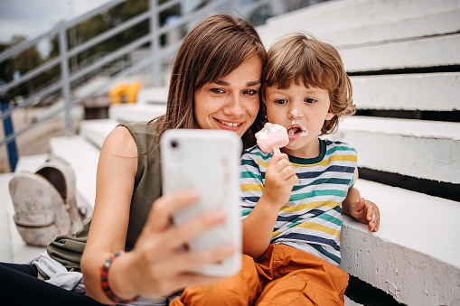 Mother and son eat ice cream and take selfies