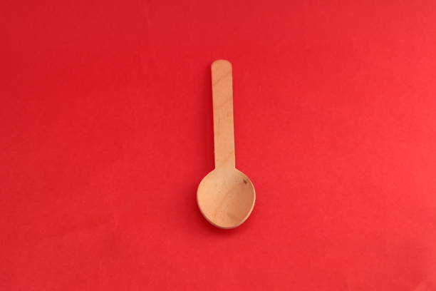 istock spoon made of wood on a red background 1402496989