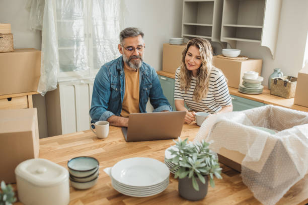 istock Mature Couple with Moving Boxes in New Home 1402501761