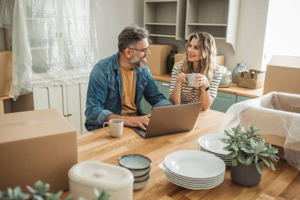 istock Mature Couple with Moving Boxes in New Home 1402501769