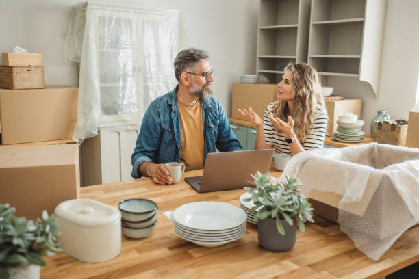 istock Mature Couple with Moving Boxes in New Home 1402501773