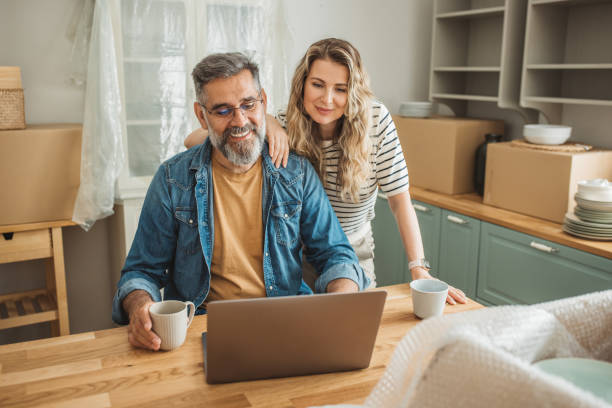 istock Mature Couple with Moving Boxes in New Home 1402501778