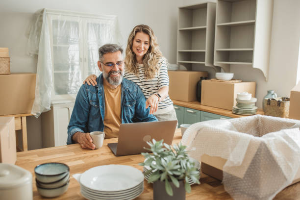 istock Mature Couple with Moving Boxes in New Home 1402501780