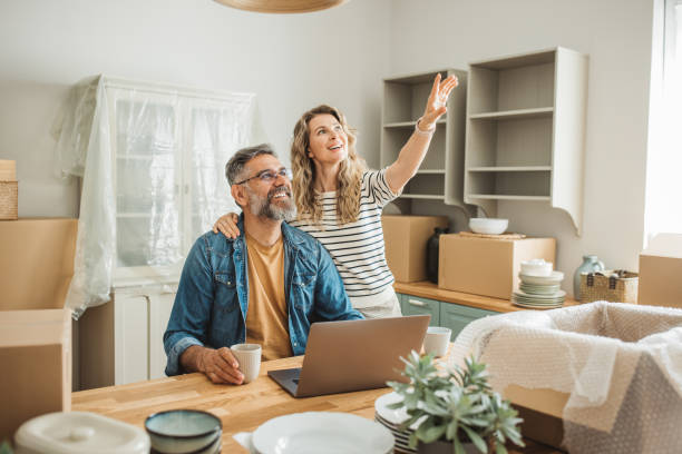 istock Mature Couple with Moving Boxes in New Home 1402501782