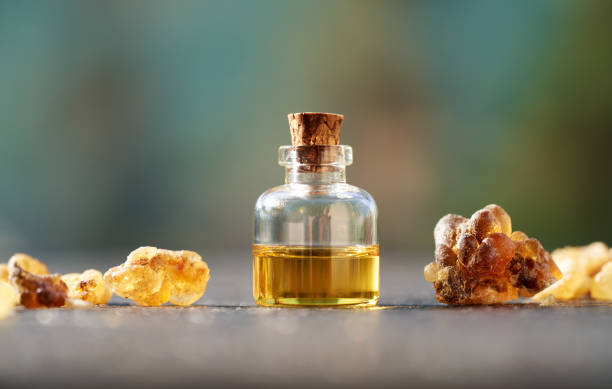 a bottle of frankincense essential oil with frankincense resin crystals - tree resin imagens e fotografias de stock