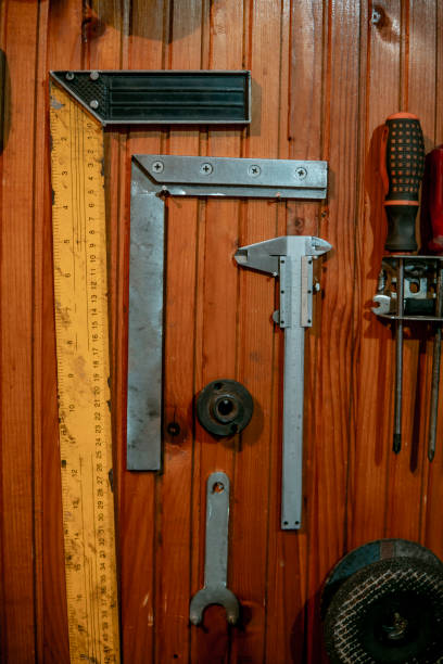 istock Two protractors and a caliper and a clamp hung on a wooden wall. 1402504358