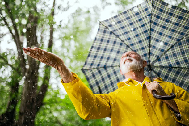istock Senior man walking on a raining day with umbrella 1402507563