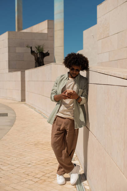 istock Good-looking African American man using phone outdoors 1402508973