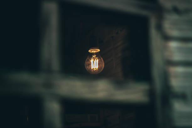 Warm white light bulb in dark room with white room