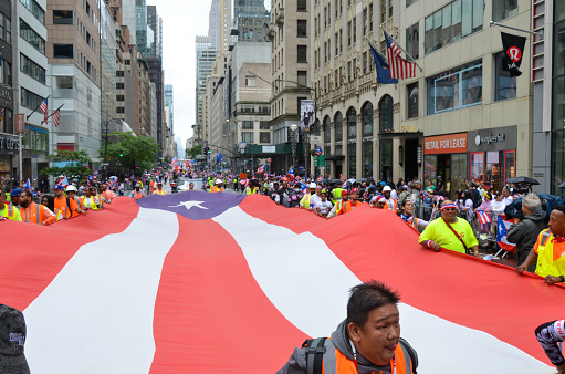 Participants are seen holding a huge Puerto Rican flag on Fifth Avenue in New York City during the National Puerto Rican Day Parade, returning after a two-year-hiatus due to the pandemic, on June 12, 2022.