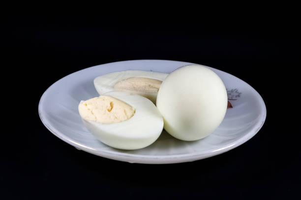istock Hard boiled egg on white plate isolated on black background 1402512699