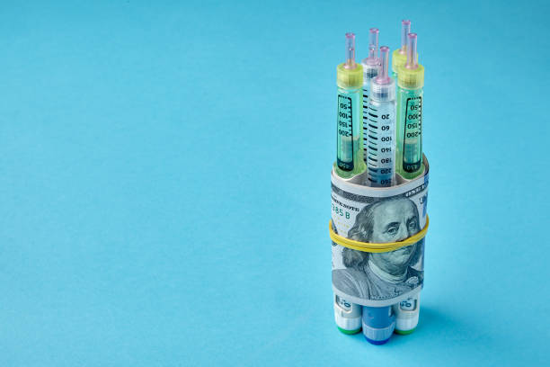 istock nsulin syringe pens wrapped in dollar bills on a blue background 1402515641