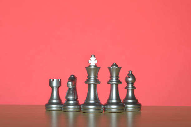 istock Set of chess figures in a row isolated on a red background 1402519217
