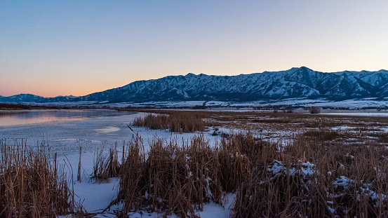 Beautiful sunset over frozen Little Bear River, Logan, Utah, USA