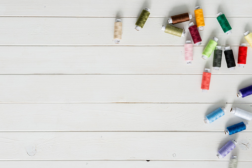 white wooden planks background with colorful thread skeins with text space