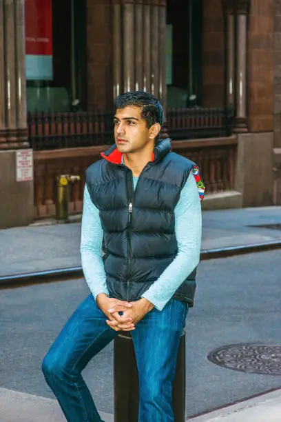 Photo of Young man sitting on street in New York City