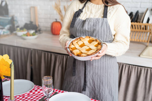 istock woman preparing pumpkin pie for thanksgiving dinner at home kitchen 1402527075