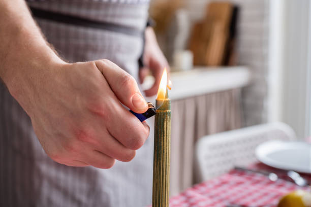 istock man preparing thanksgiving dinner at home kitchen, lighting candles 1402527174