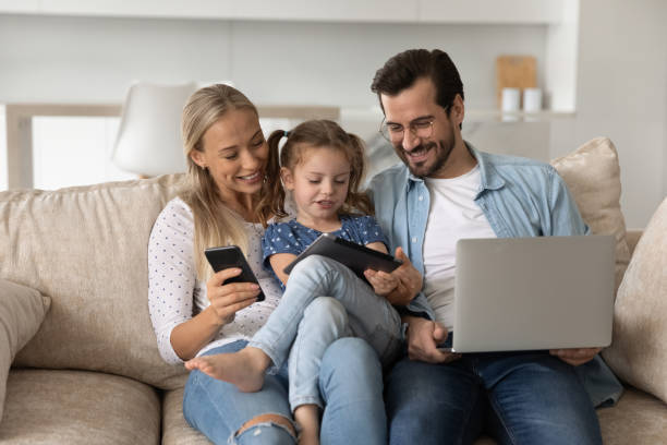 istock Happy bonding family couple and little kid using different gadgets. 1402529766