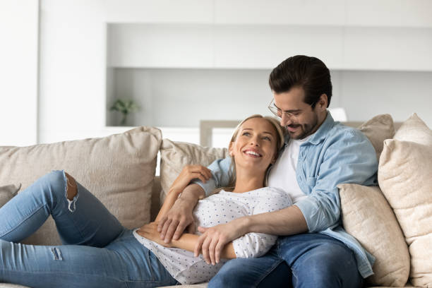istock Joyful affectionate family couple relaxing on comfortable sofa. 1402529840